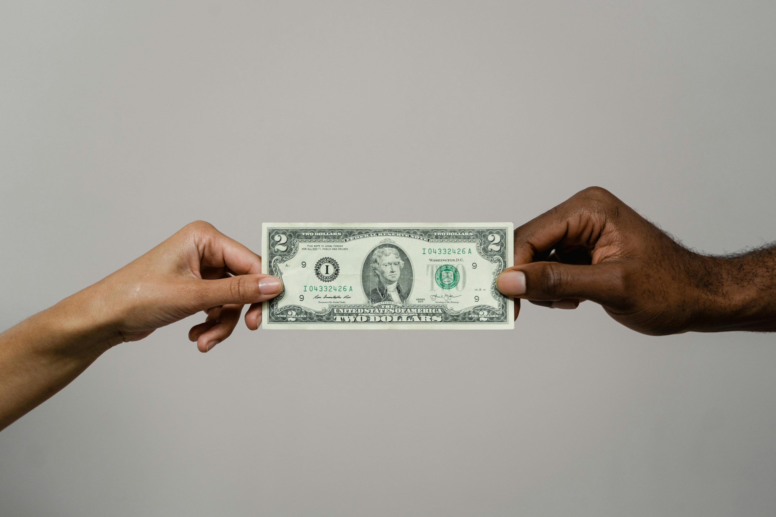 Two hands holding a banknote, symbolizing faithful stewardship and managing money God’s way according to biblical principles.