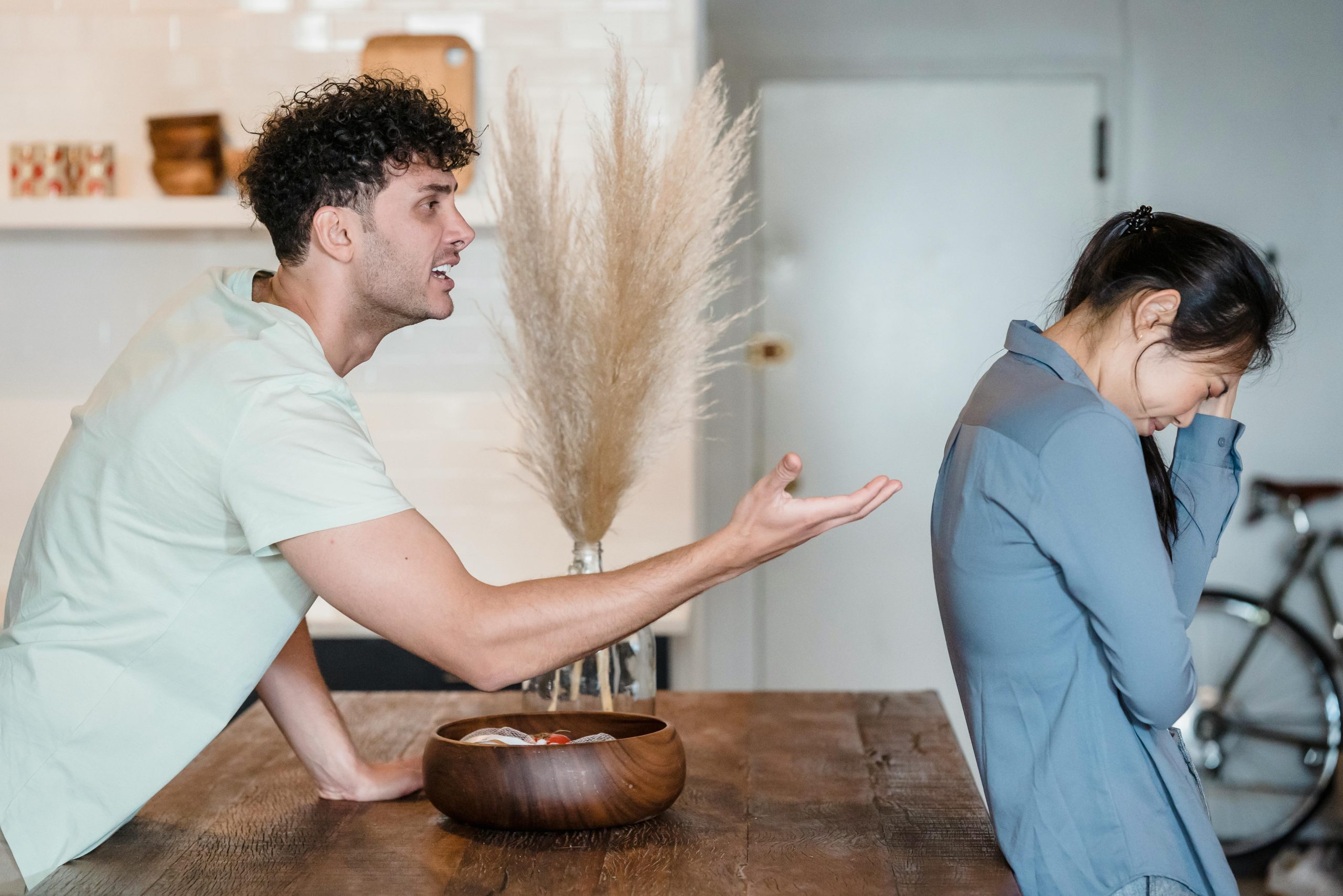A man and a woman in a heated argument at home, illustrating the need for learning how to resolve conflict God’s way.