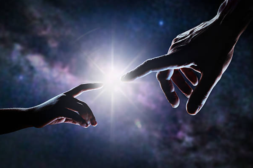 A divine hand reaching out to a human hand with light in the center, symbolizing the question: is god really good when bad things happen?