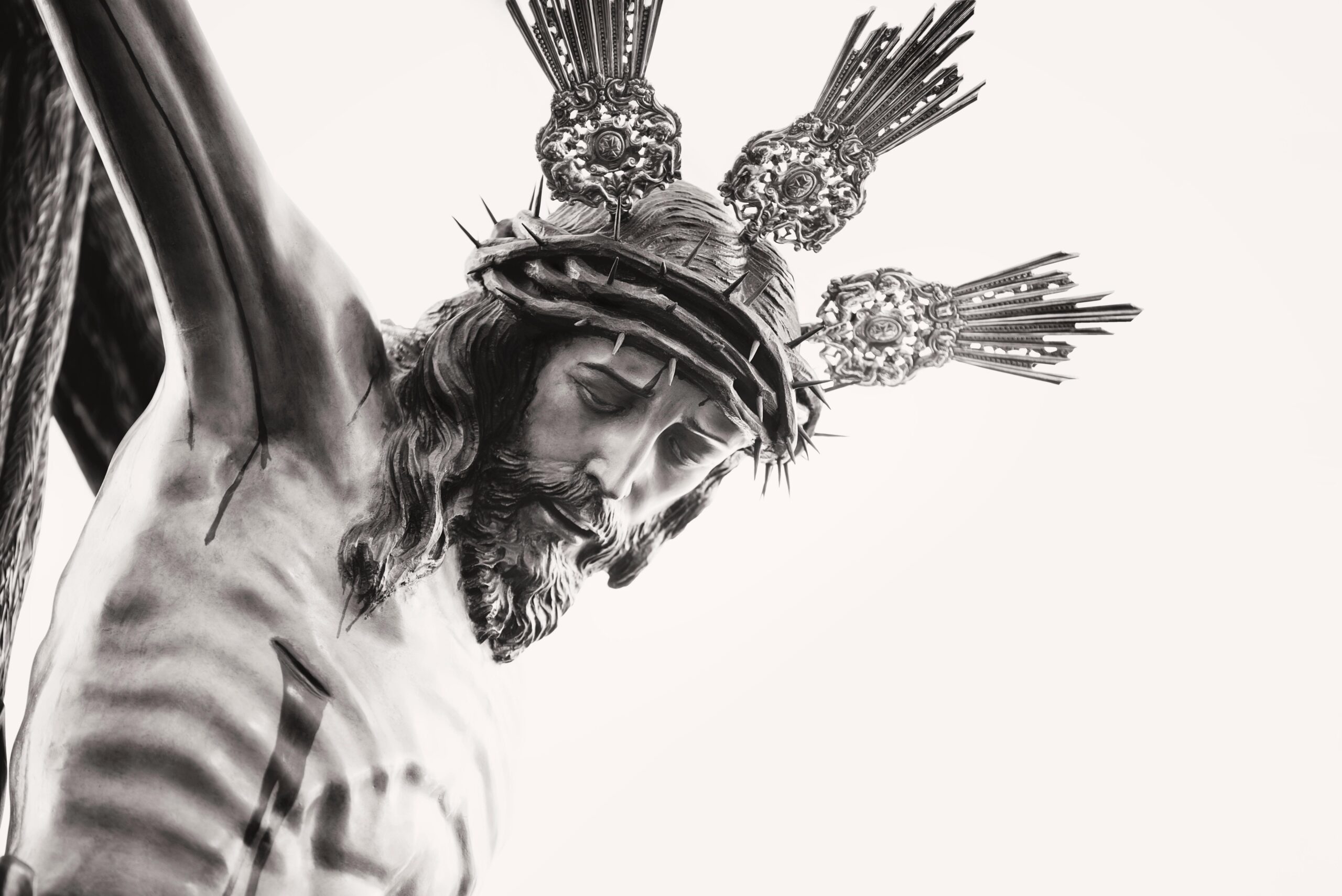 A stone statue of Jesus Christ on the cross, representing Who is Jesus and His identity.